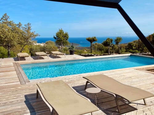 Élégante piscine des Villas d'A Storia avec vue sur la mer Méditerranée, transats et paysage côtier à Porto-Vecchio
