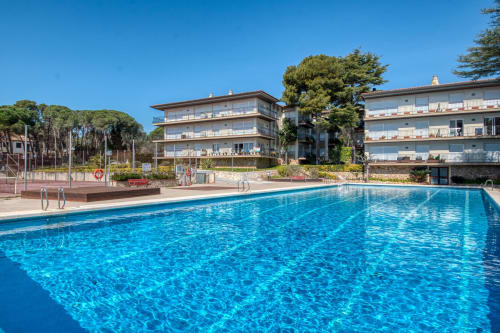 Finques Garcia Enrich apartment resort with sparkling blue swimming pool, garden views, and Mediterranean architecture in