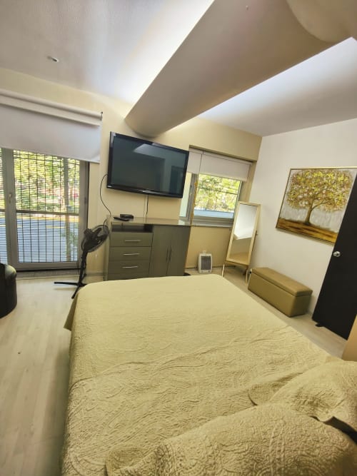 Moderna recámara en Capital Park Condos, Condesa/Roma, Ciudad de México con cama queen, TV y vistas a la ciudad