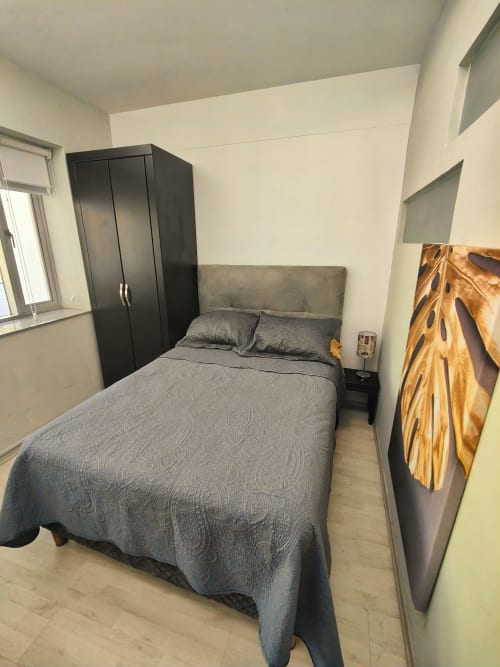 Habitación moderna en Capital Park Condos, Condesa/Roma, Ciudad de México con cama gris, armario negro y vista a la ciudad