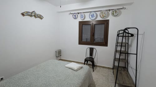 Dormitorio en la villa Casa Rural Ribera del Hueznar, Constantina, Cazalla de la Sierra , con cama, platos decorativos y vistas a la sierra