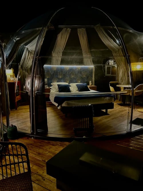 Chambre bulle transparente avec lit à baldaquin, jacuzzi privé et vue étoilée à l'hôtel Bubble Jade de Bazouges-la-Pérouse