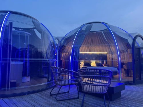 Bulles transparentes éclairées de néons bleus à l'hôtel Bubble Jade, avec espaces extérieurs et bains à remous privés