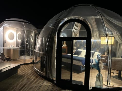 Chambre dôme bulle transparente la nuit avec bain à remous privé, intérieur illuminé et vue sur le jardin à Bubble Jade