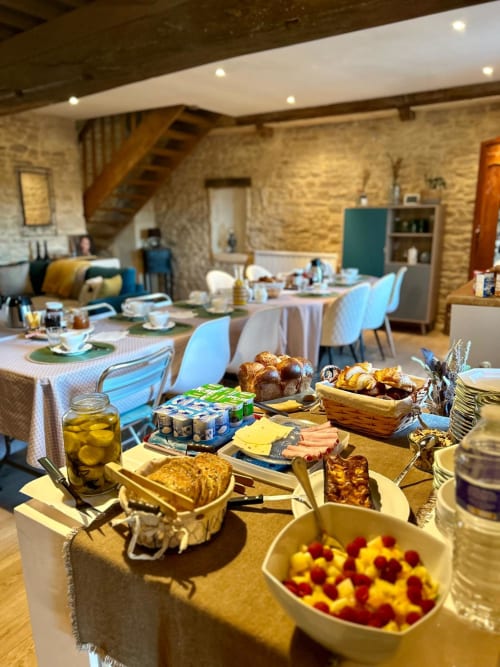Buffet du petit-déjeuner à La Maison de la Colline B&B à Vers, France avec pâtisseries fraîches, fruits et tables de salle à manger