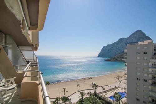 Beachfront balcony view of Calpe's turquoise Mediterranean waters and rocky coastline from Riurau Home apartment