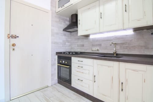 Modern kitchen with white cabinets, dark countertops, and subway tile backsplash in Turmalina 10 apartment, Calpe
