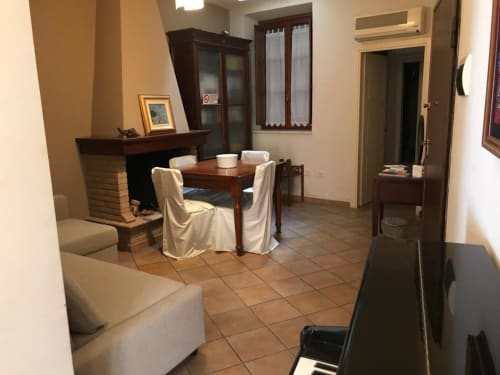 Affittacamere Numero3, zona comune a Cagliari con tavolo da pranzo, camino e arredamento in tonalità crema