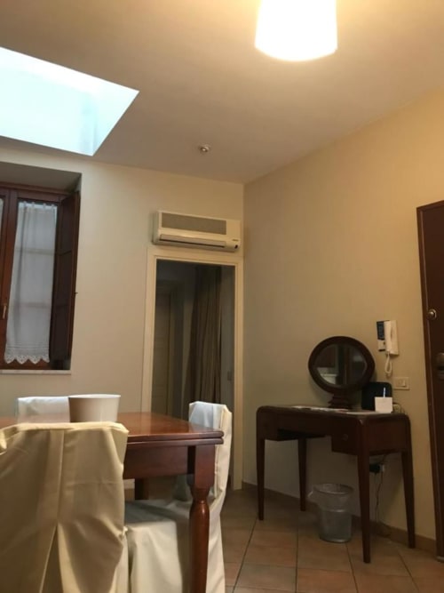 Camera presso Affittacamere Numero3 a Cagliari con scrivania, sedia, tavolo in legno, lucernario e condizionatore