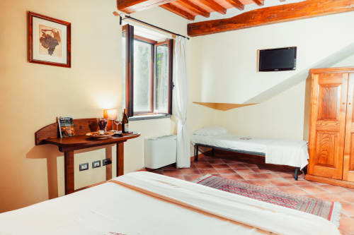 Spacious bedroom with wooden beams, desk, TV, and garden view at Aglianico Country House Le Vigne in Cataldo