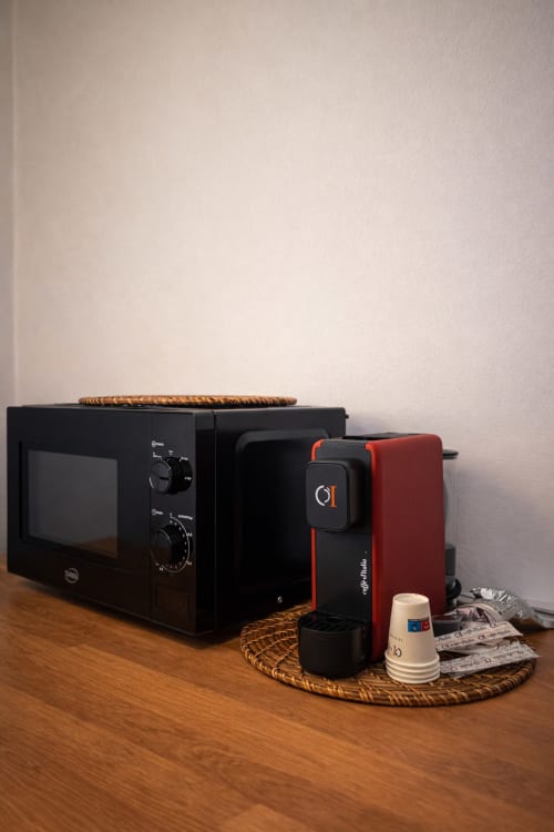 Black microwave and red coffee maker on wooden counter at SambaSStays Cataldo apartment