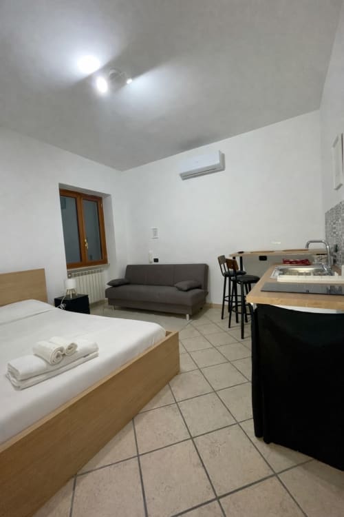 Studio apartment at SambaSStays in Cataldo featuring bed, sofa, kitchenette and modern amenities