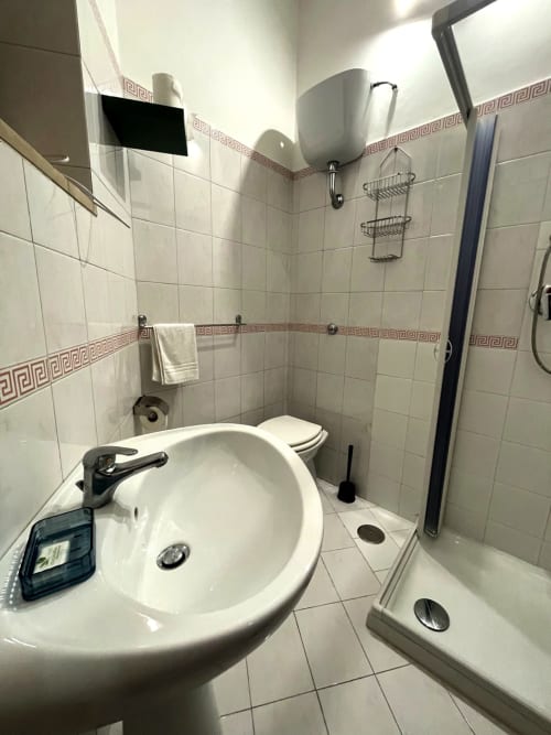 Modern bathroom in SambaSStays Carioca apartment, Cataldo, featuring round sink, toilet, and shower enclosure with tiled