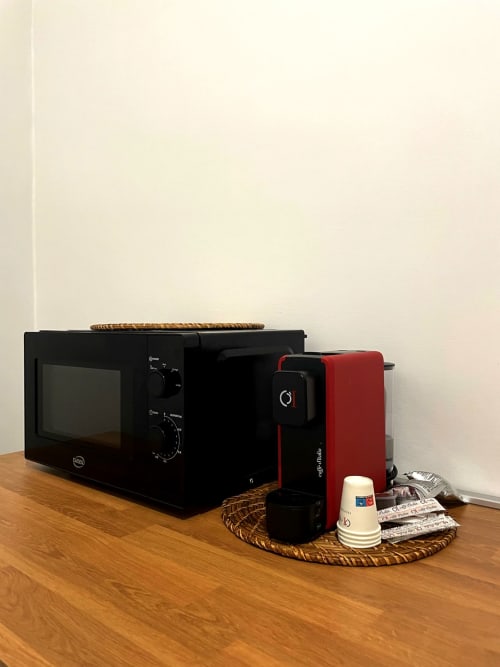 Kitchen corner at SambaSStays Carioca apartment in Cataldo with microwave, red coffee maker, and kitchenware accessories on