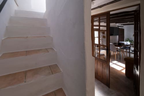 Escalera luminosa con peldaños de madera y paredes blancas en Casita del Río, El Batán Hotel Spa, Castillo de