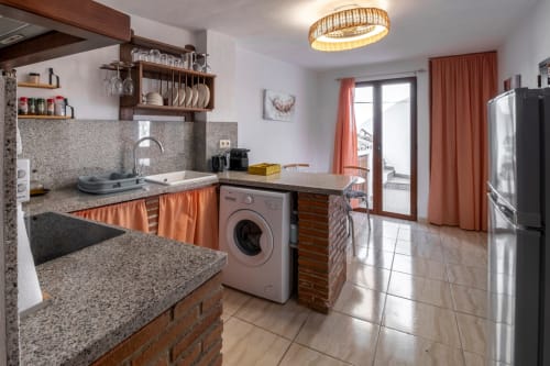 Cocina moderna en apartamento Casita del Río 2 de El Batán Hotel Spa con encimeras de granito, lavadora y vista al río