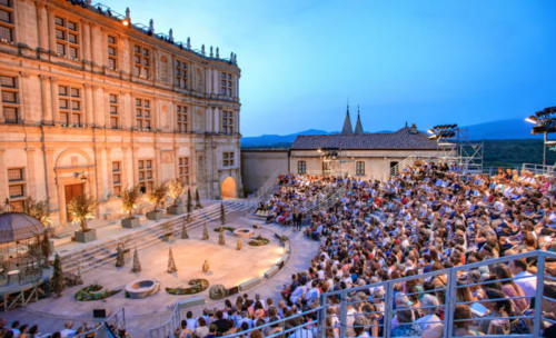 Spectacle de théâtre en plein air au Pied de la Lettre à Grignan, cour illuminée et public assis