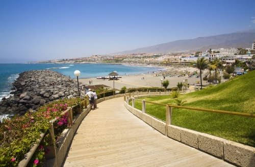 Coastal promenade overlooking sandy beach and turquoise sea in Costa Adeje, Tenerife