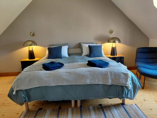Quarto moderno em Gites au fil des châteaux de la Loire com detalhes em azul, luminárias de cabeceira e piso em madeira em Saint
