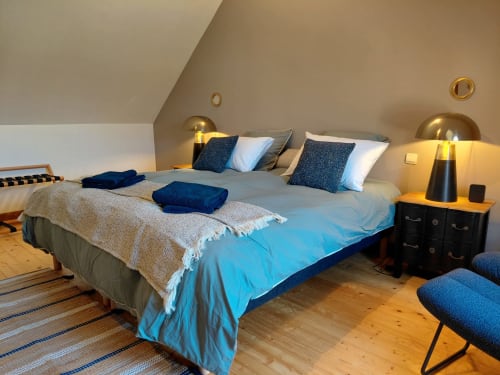 Quarto moderno em Gites au fil des châteaux de la Loire com cama azul, luminárias douradas e piso de madeira