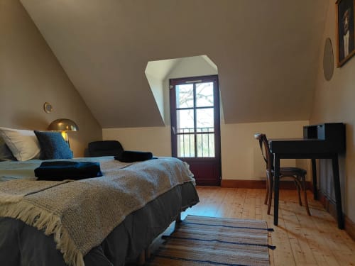 Quarto luminoso na mansarda do Gites au fil des châteaux de la Loire com cama, escrivaninha, claraboia e pisos em madeira em Saint