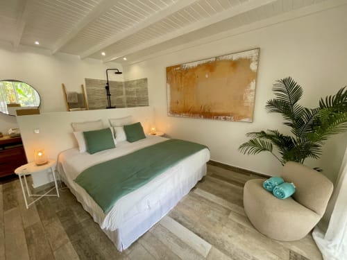 Chambre moderne du studio Sunseeker Sxm, Saint-Martin avec accents verts, lit king-size, plante et vue montagne
