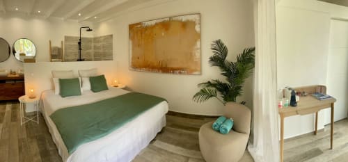Chambre moderne du studio Sunseeker Sxm avec literie verte, plante en pot, œuvre d'art et vue sur les montagnes à Saint-Martin