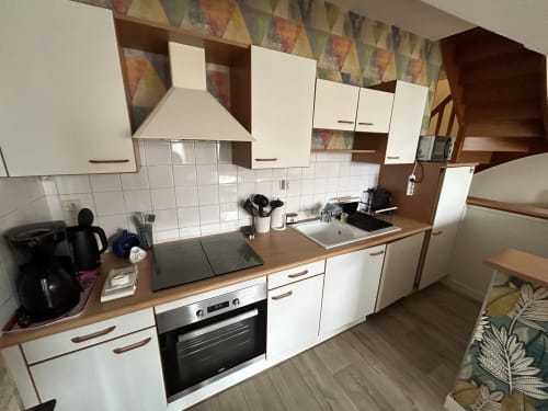 Kitchenette moderne de l'appartement Le Grand Paradis chez Marie Et Jean François, Dol de Bretagne avec meubles blancs et cuisinière