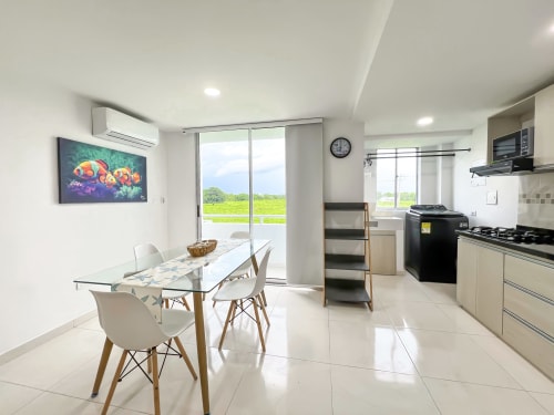 Cocina y comedor moderno en apartamento Olamar Living, Coveñas, con vistas al lago y electrodomésticos de acero inoxidable