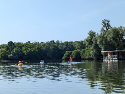 Kayakers and paddleboarders enjoying water activities on Saône River at Domaine Saône Valley in Traves