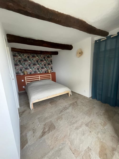 Spacieuse chambre à la villa Altezza Brando avec poutres apparentes, lit queen-size et tête de lit, papier peint à motifs