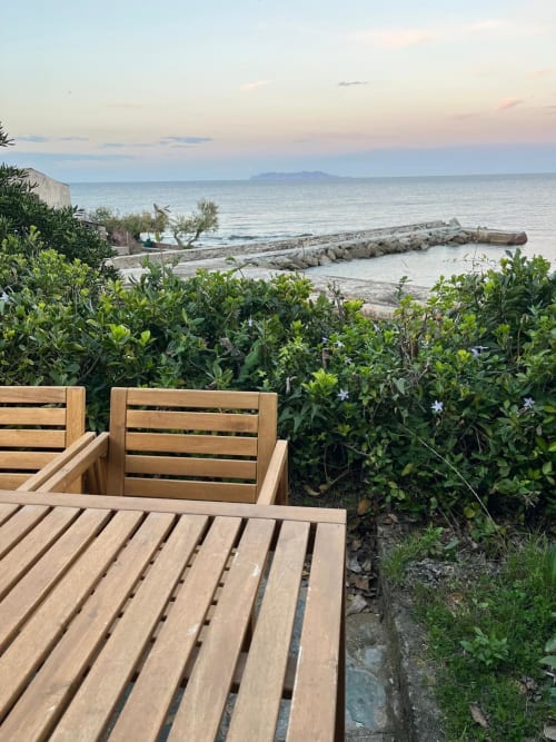 Chaises longues en bois sur la terrasse face à la mer de la villa Altezza à Brando, Corse