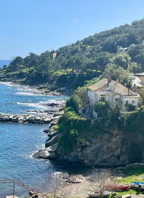 Villa Altezza à Brando avec vue sur mer, perchée sur la côte rocheuse dominant la Méditerranée avec verdure luxuriante et cyprès