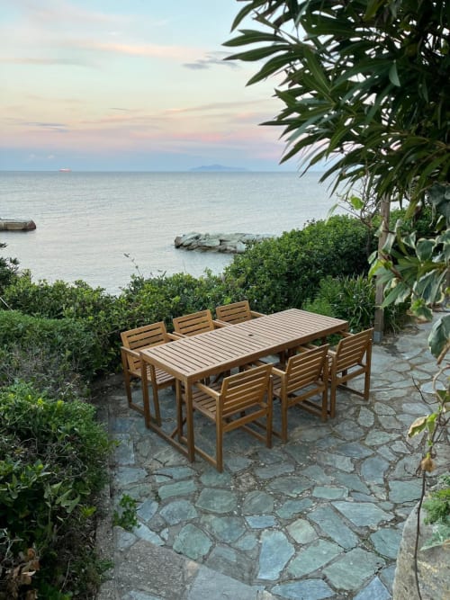 Table et chaises en bois sur terrasse en pierre avec vue sur la Mer Tyrrhénienne, villa Altezza à Brando, Corse