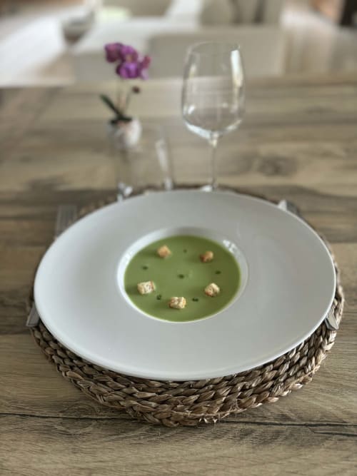Élégant velouté vert servi au Jardin d'Elusa, gîte français à Eauze, garni de fleurs violettes et vin