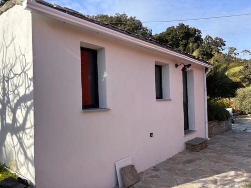Appartement rose avec porte et fenêtres rouges, Maison les Pieds dans l'eau, propriété en bord de plage à Erbalunga, Brando, Corse