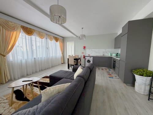 Isabella's House villa in Ribeira Brava with open-plan living, kitchen, gray sofa, and golden curtains