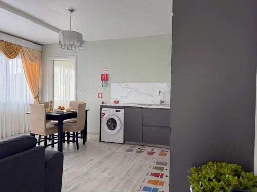 Isabella's House kitchen-living area with washing machine, dining table, and modern amenities in Ribeira Brava villa