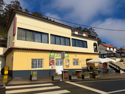 Bright yellow and black villa Isabella's House in Ribeira Brava, Madeira with street parking and outdoor seating area