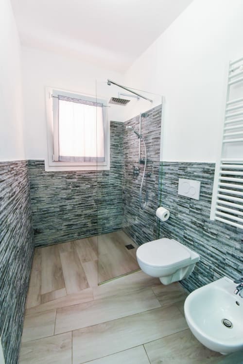 Bagno moderno nell'appartamento di Varigotti con piastrelle verdi a righe, doccia walk-in, WC, bidet e lavabo