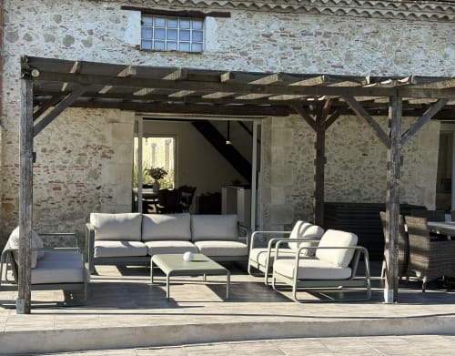 Patio du Jardin d'Elusa avec pergola en bois, places assises extérieures et bâtiment en pierre à Eauze