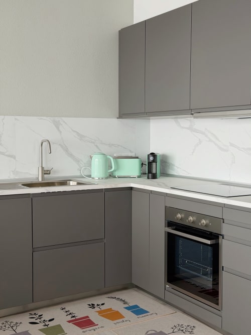 Cozinha moderna do hotel Check Madeira em Ribeira Brava com armários cinzentos, backsplash em mármore e eletrodomésticos menta