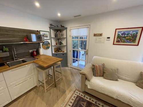 Cocina y sala de estar de villa moderna diáfana con sofá crema, mesa de madera y vistas a las montañas en Lanzarote