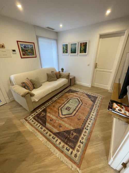 Luminoso salón con sofá crema, alfombra decorativa, cuadros enmarcados y equipamientos modernos en villa Yaiza, Lanzarote