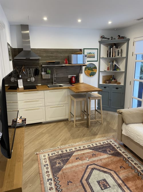 Cocina moderna con gabinetes crema, backsplash negro, encimeras de madera e isla con asientos en villa en Playa Blanca