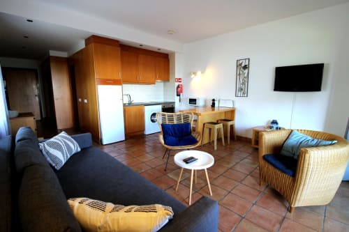 Apartamento Villa Alegria em Lagos com sala integrada, cozinha, área de estar e TV