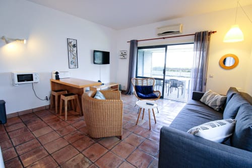 Elegante sala de estar moderna na Villa Alegria, Zonas Mágicas Lagos com vista para o mar, decorada com sofá azul e mesa de jantar