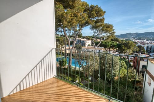 Terrassa de fusta amb vistes a la ciutat de l'hotel Finques Garcia Enrich a Palafrugell, dominant la piscina i la Mediterrània