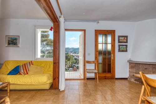 Sala de estar brillant amb sofà groc a Finques Garcia Enrich a Palafrugell, vistes al mar i detalls de fusta