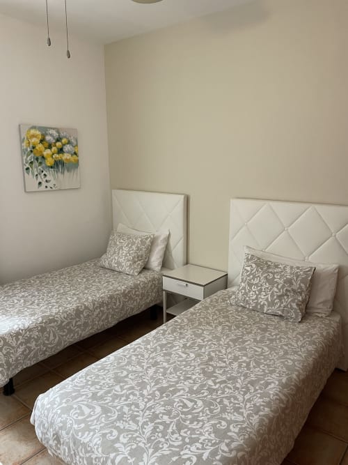 Camas gemelas con ropa de cama estampada y cabeceros acolchados en Villa Pola Marinas, Playa Blanca Lanzarote